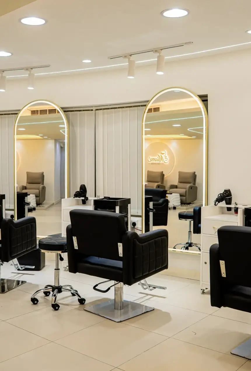 Black leather styling chairs in front of arched mirrors that reflect the pedicure area